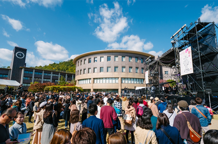 The expectant crowds gather at the festival stage on a sunny autumn day at Ritsumeikan University's Kinugasa Campus in Kyoto