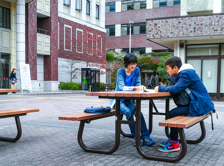 Sitting outside on a bench near the College of International Relations buildings - Ritsumeikan University Kinugasa Campus