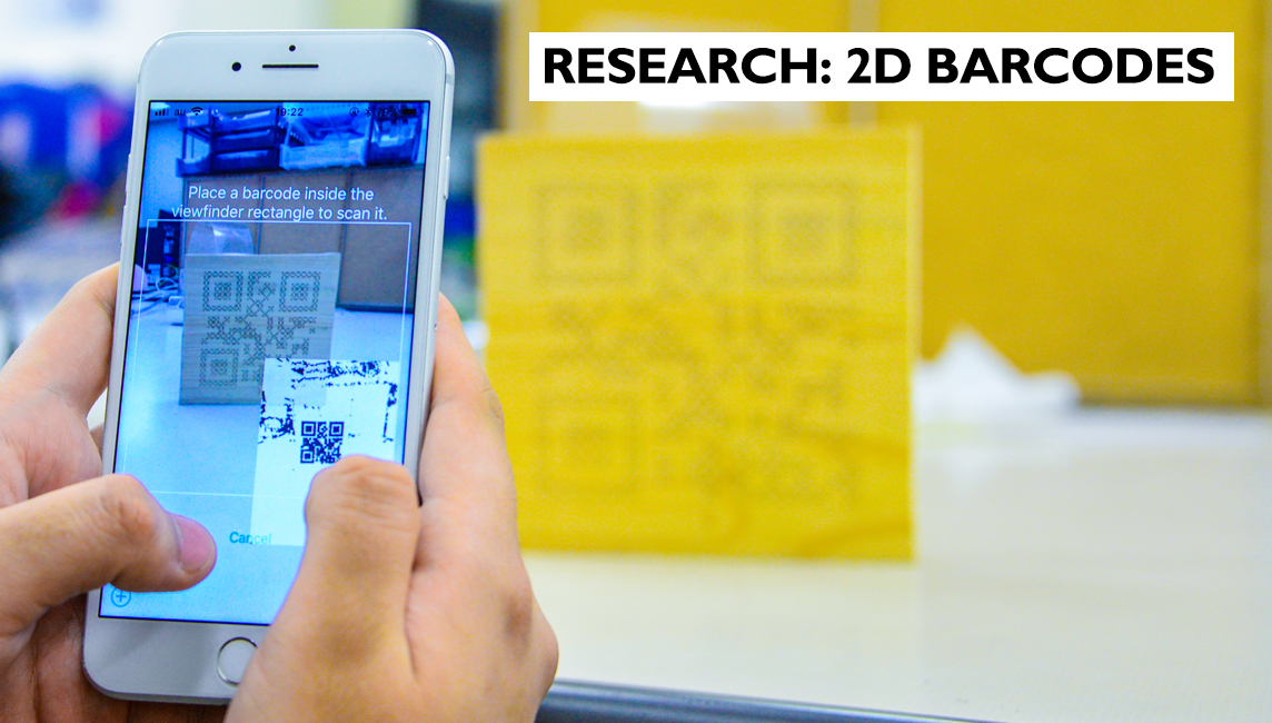 A smart phone takes a snapshot of a 2D Porous Code engraved onto a wooden surface - Research at Ristumeikan University 