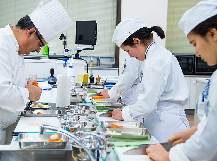 Le Cordon Bleu Chef Gilles Company leads students through an exercise in cutting and chopping vegetables in different ways with consistency