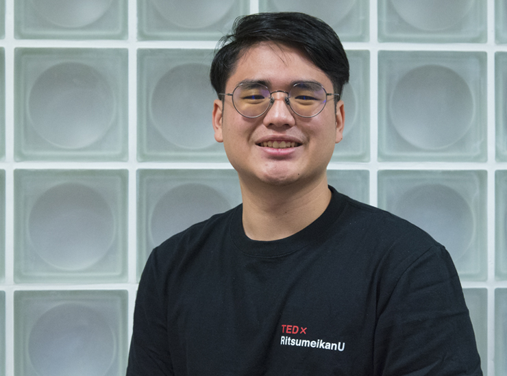 Willy Lin faces the camera wearing a black T-shirt bearing the logo for the event TEDx Ritsumeikan U