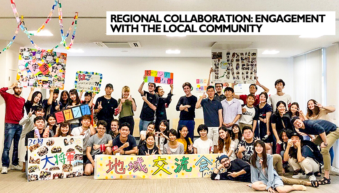 Thirty plus Students at Ritsumeikan's Kinugasa Kyoto Campus welcome the Local Community holding up welcome signs in a dormitory common room   