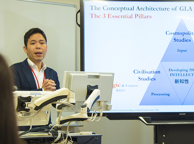 Professor Choi speaks in front of a large multi-touch interactive display 