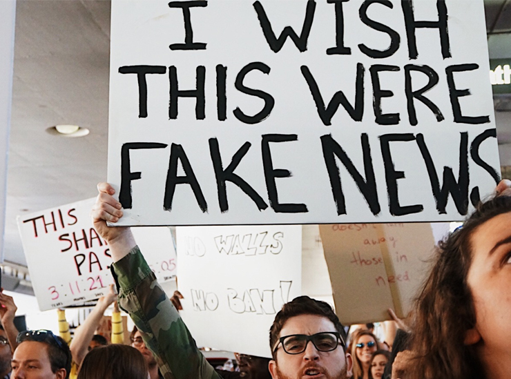 Image of placard being held up at a demonstration saying I wish this were fake news