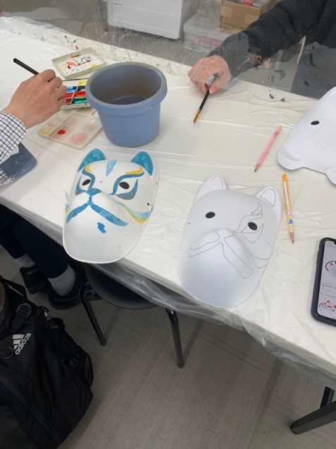 two half-painted kitsune masks on a table