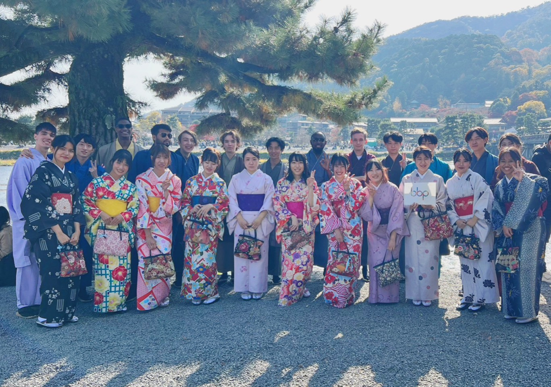 Group photo of students in kimonos in front of a large tree