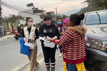 Students hand out flyers to encourage recycling